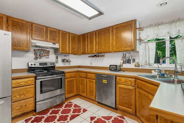 238 Red Fox Rd, Lolo, MT 59847 - kitchen featuring stainless steel appliances, under cabinet range hood, a sink, and light countertops