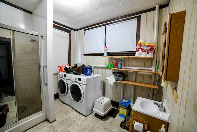 712 9th St N, Great Falls, MT 59401 - washroom featuring washing machine and dryer, wooden walls, and a sink
