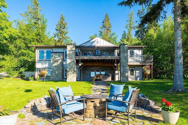 34777 Compass Ln, Polson, MT 59860 - rear view of house with a fire pit, a balcony, a lawn, and board and batten siding