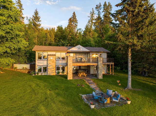 34777 Compass Ln, Polson, MT 59860 - rear view of house with a patio area, a deck, a lawn, and a wooded view