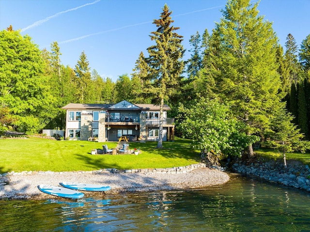 34777 Compass Ln, Polson, MT 59860 - rear view of property featuring a lawn, a deck with water view, and a view of trees