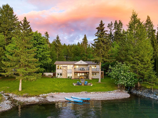 34777 Compass Ln, Polson, MT 59860 - back of property with a lawn, a wooded view, and a deck with water view
