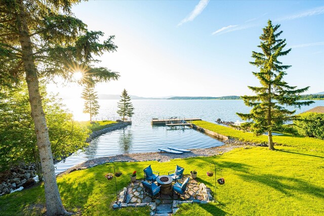 34777 Compass Ln, Polson, MT 59860 - dock featuring a water view, an outdoor fire pit, and a lawn