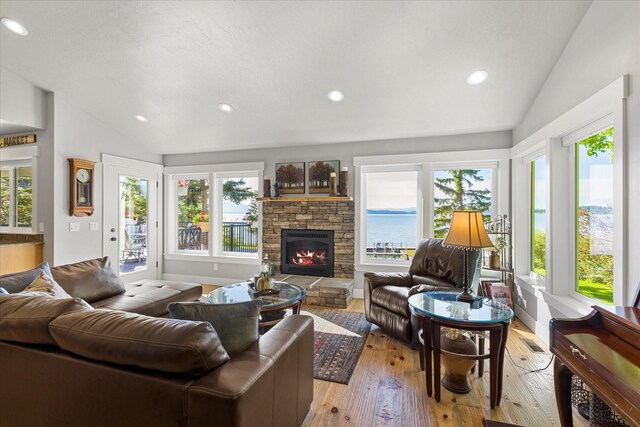 34777 Compass Ln, Polson, MT 59860 - living area with vaulted ceiling, healthy amount of natural light, a fireplace, recessed lighting, and light wood-style floors