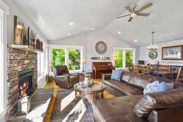 34777 Compass Ln, Polson, MT 59860 - living area featuring a stone fireplace, vaulted ceiling, wood finished floors, ceiling fan, and recessed lighting