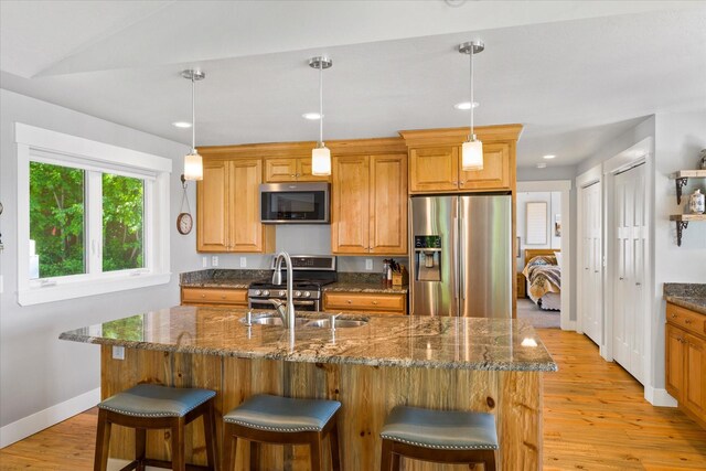 34777 Compass Ln, Polson, MT 59860 - kitchen with appliances with stainless steel finishes, light wood-type flooring, a sink, a breakfast bar area, and baseboards
