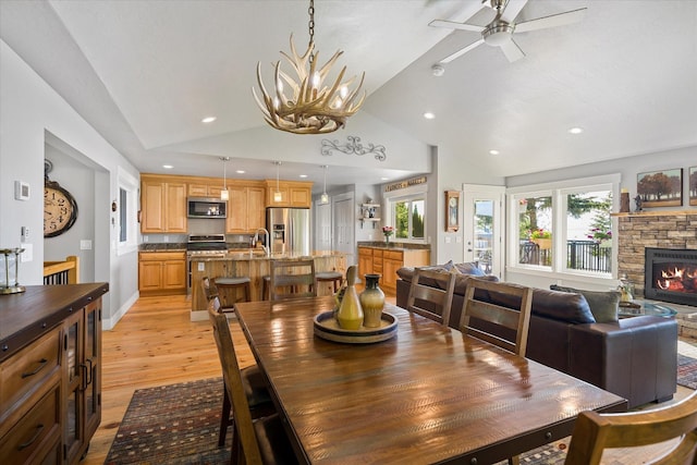 34777 Compass Ln, Polson, MT 59860 - dining space with vaulted ceiling, light wood-style flooring, ceiling fan, a chandelier, and healthy amount of natural light