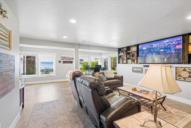 34777 Compass Ln, Polson, MT 59860 - living room featuring baseboards, finished concrete flooring, plenty of natural light, recessed lighting, and a textured ceiling