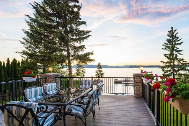 34777 Compass Ln, Polson, MT 59860 - deck at dusk featuring a water view and outdoor dining area