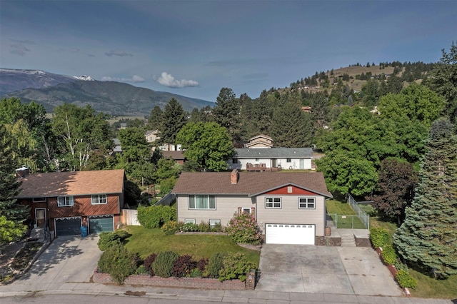 239 Essex St, Lolo, MT 59847 - view of front of property with a garage, concrete driveway, a mountain view, and a front yard