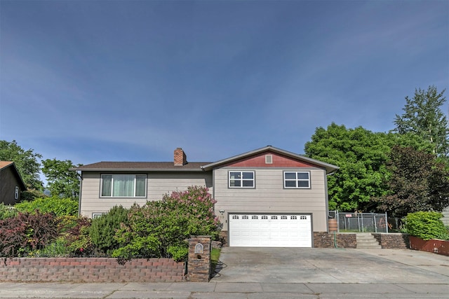 239 Essex St, Lolo, MT 59847 - view of front of house with an attached garage, driveway, and a chimney