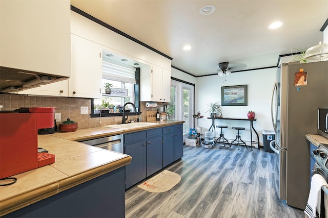 239 Essex St, Lolo, MT 59847 - kitchen with a sink, appliances with stainless steel finishes, white cabinetry, tile counters, and dark wood-style flooring