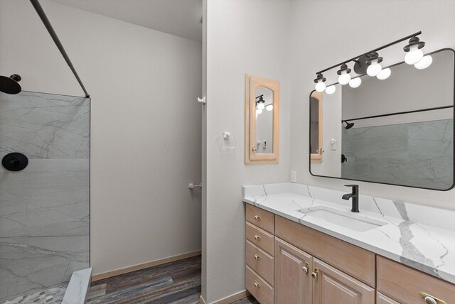 35280 Bennington Ln, Polson, MT 59860 - full bathroom featuring a marble finish shower, vanity, wood finished floors, and baseboards