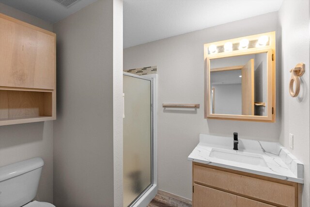 35280 Bennington Ln, Polson, MT 59860 - full bathroom featuring vanity, a stall shower, toilet, and wood finished floors