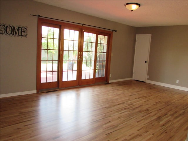 706 49th St S, Great Falls, MT 59405 - empty room with wood finished floors, baseboards, and french doors