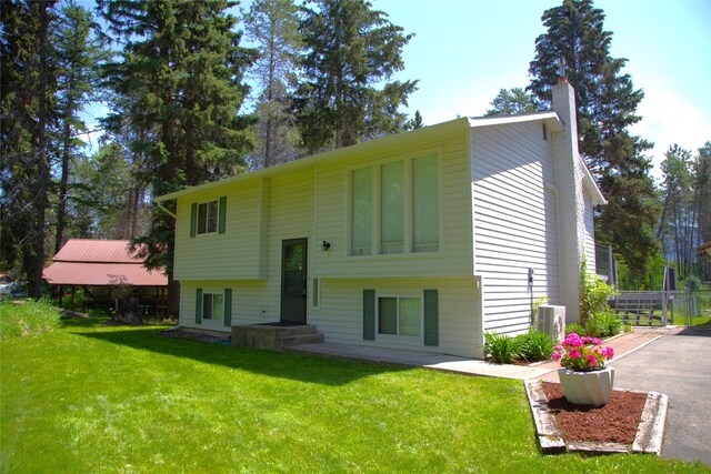 189 Dawn Dr, Columbia Falls, MT 59912 - split foyer home featuring a front yard, a chimney, and ac unit