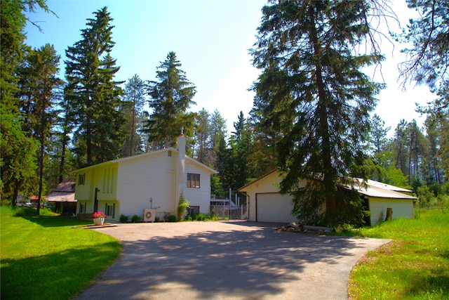 189 Dawn Dr, Columbia Falls, MT 59912 - view of side of property with a garage, a chimney, a yard, and an outdoor structure