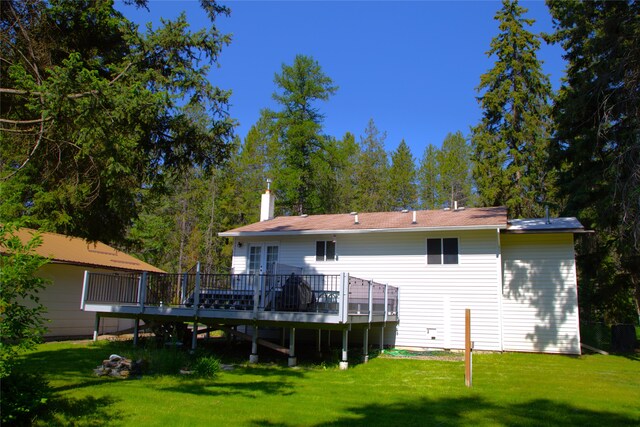 189 Dawn Dr, Columbia Falls, MT 59912 - rear view of property with a wooden deck, a yard, and a chimney