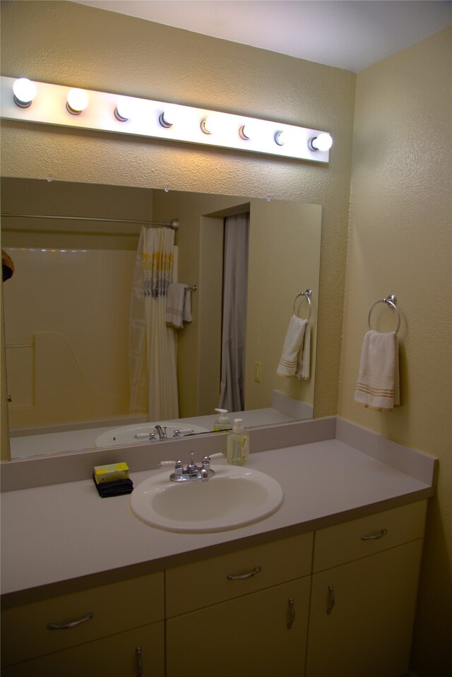 189 Dawn Dr, Columbia Falls, MT 59912 - bathroom featuring vanity, a textured wall, and curtained shower
