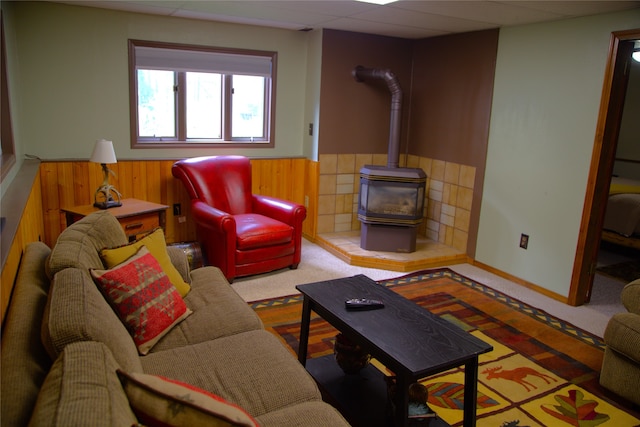 189 Dawn Dr, Columbia Falls, MT 59912 - living area featuring a wood stove, carpet, a wainscoted wall, and wood walls