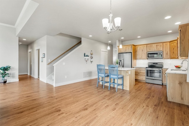 2390 38th St, Missoula, MT 59801 - kitchen featuring stainless steel appliances, a kitchen breakfast bar, light countertops, light wood finished floors, and a center island