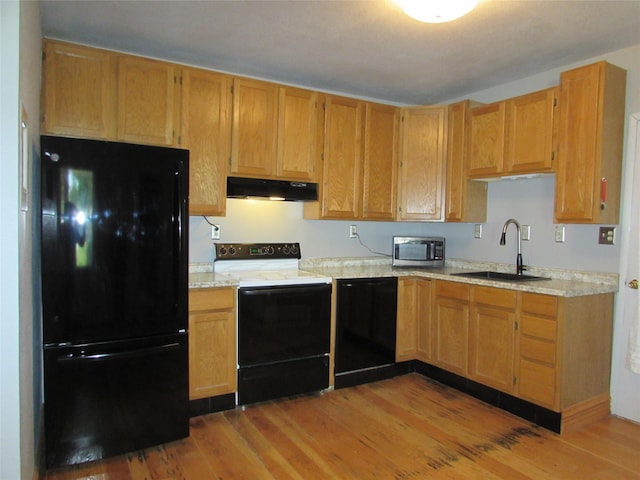 2323 3rd Ave S, Great Falls, MT 59405 - kitchen with black appliances, a sink, under cabinet range hood, and light wood-style flooring