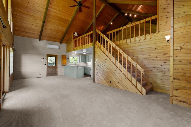 45 Panoramic Dr, Kalispell, MT 59901 - unfurnished living room with wooden walls, carpet flooring, wooden ceiling with exposed beams, high vaulted ceiling, and stairs