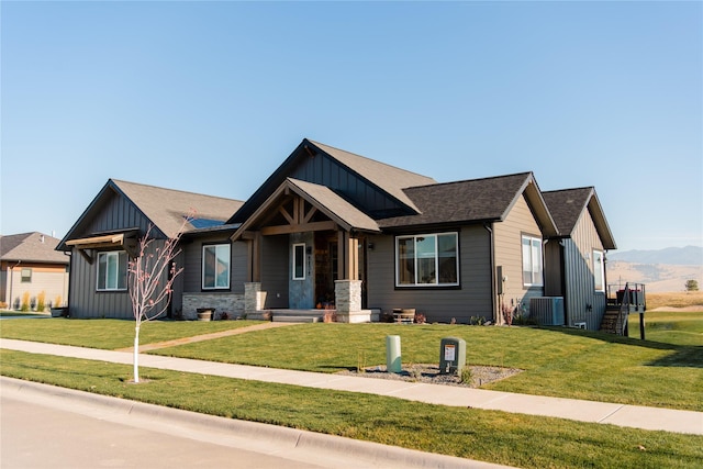 8138 Ranch Club Rd, Missoula, MT 59808 - craftsman house featuring board and batten siding, a front yard, central AC unit, a mountain view, and stone siding