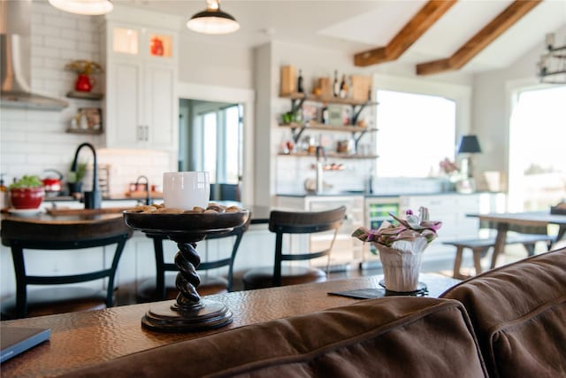 8138 Ranch Club Rd, Missoula, MT 59808 - kitchen with backsplash, white cabinetry, extractor fan, beam ceiling, and glass insert cabinets