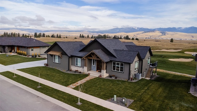 8138 Ranch Club Rd, Missoula, MT 59808 - view of front of property featuring roof with shingles, a mountain view, a front lawn, cooling unit, and driveway