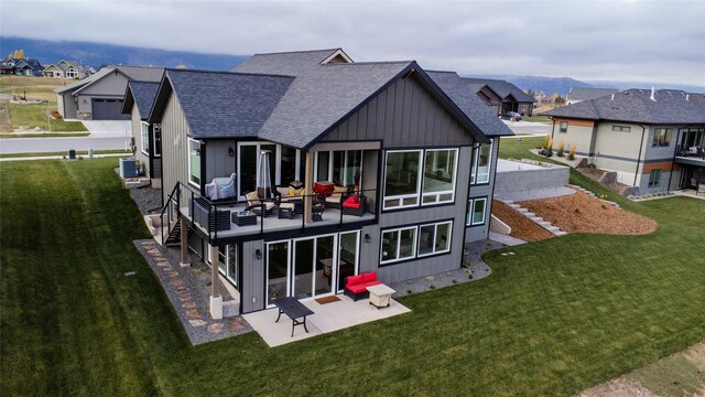 8138 Ranch Club Rd, Missoula, MT 59808 - back of property with a shingled roof, board and batten siding, a lawn, and a patio
