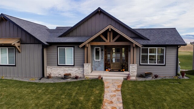 8138 Ranch Club Rd, Missoula, MT 59808 - view of front of property featuring a front lawn, roof with shingles, stone siding, and board and batten siding