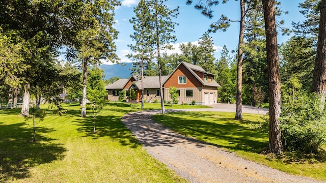 1265 Jellison Rd, Columbia Falls, MT 59912 - view of front of property with gravel driveway, a garage, a front yard, and a mountain view