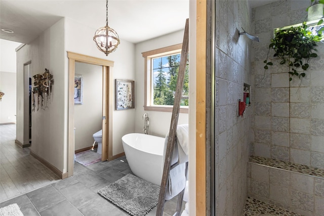 1265 Jellison Rd, Columbia Falls, MT 59912 - bathroom with a soaking tub, tiled shower, and a chandelier