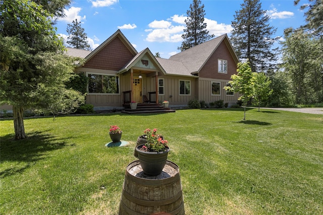 1265 Jellison Rd, Columbia Falls, MT 59912 - view of front of property featuring board and batten siding, a front lawn, and a shingled roof