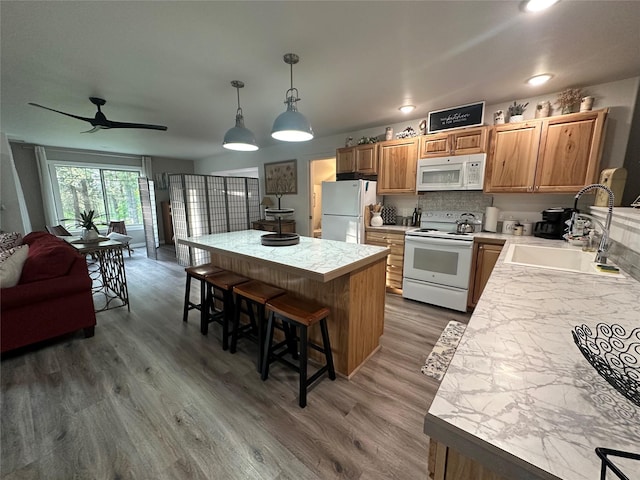 1265 Jellison Rd, Columbia Falls, MT 59912 - kitchen featuring white appliances, wood finished floors, a breakfast bar area, ceiling fan, and light countertops