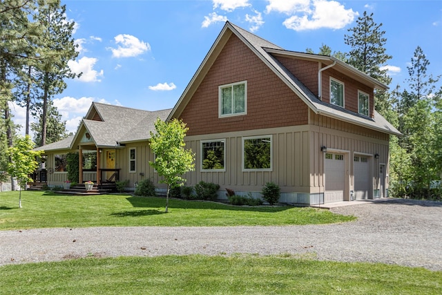 1265 Jellison Rd, Columbia Falls, MT 59912 - view of front of house with a garage, gravel driveway, board and batten siding, and a front lawn