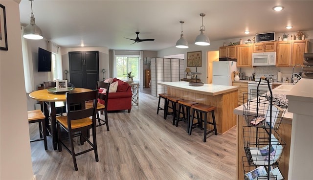 1265 Jellison Rd, Columbia Falls, MT 59912 - kitchen featuring white appliances, a kitchen island, light wood-type flooring, and ceiling fan