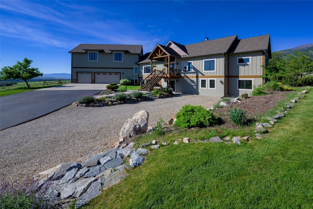 6659 Lamar Trl, Florence, MT 59833 - view of front of property with stairs, driveway, a garage, and board and batten siding