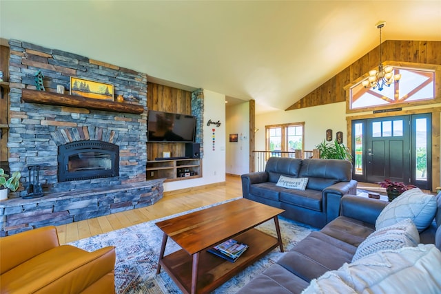 6659 Lamar Trl, Florence, MT 59833 - living room featuring a chandelier, wood-type flooring, high vaulted ceiling, a stone fireplace, and wooden walls