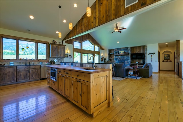 6659 Lamar Trl, Florence, MT 59833 - kitchen with dark countertops, dishwasher, light wood-type flooring, a ceiling fan, and high vaulted ceiling
