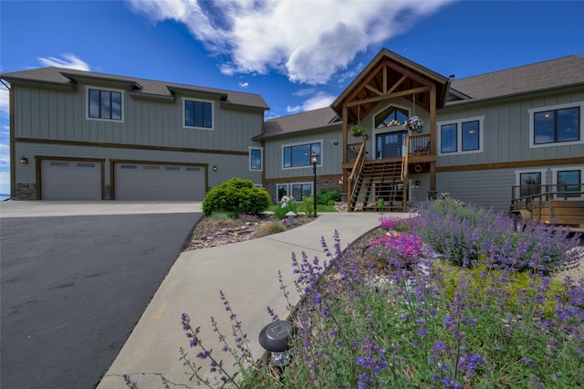 6659 Lamar Trl, Florence, MT 59833 - view of front facade featuring asphalt driveway, stairs, a garage, and board and batten siding