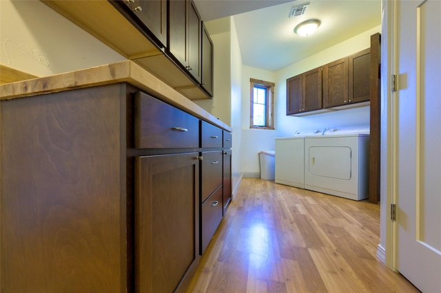 6659 Lamar Trl, Florence, MT 59833 - washroom featuring independent washer and dryer, cabinet space, and light wood-type flooring