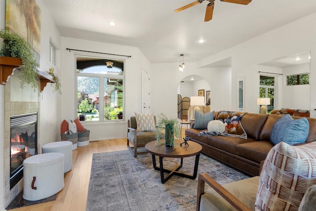 720 Anglers Bend Way, Missoula, MT 59802 - living area with arched walkways, light wood-style floors, a ceiling fan, recessed lighting, and a tiled fireplace
