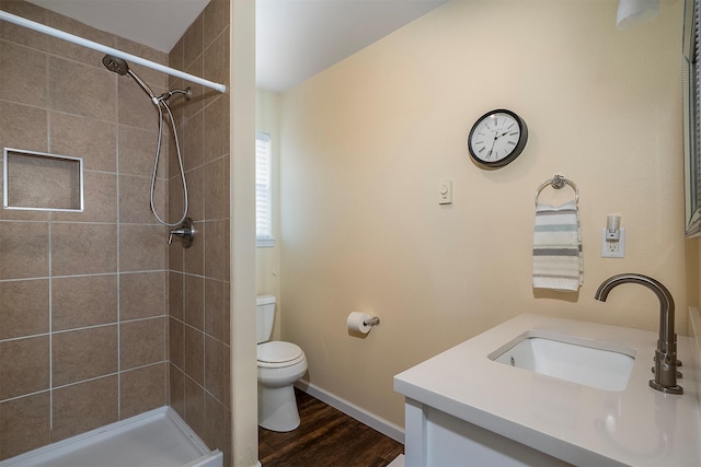 31683 S Rim Dr, Polson, MT 59860 - bathroom featuring toilet, vanity, wood finished floors, a tile shower, and baseboards