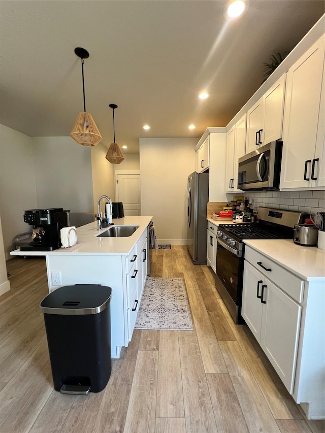 2883 Adam Run Ave, Helena, MT 59601 - kitchen featuring stainless steel appliances, a sink, a kitchen island with sink, white cabinetry, and light countertops