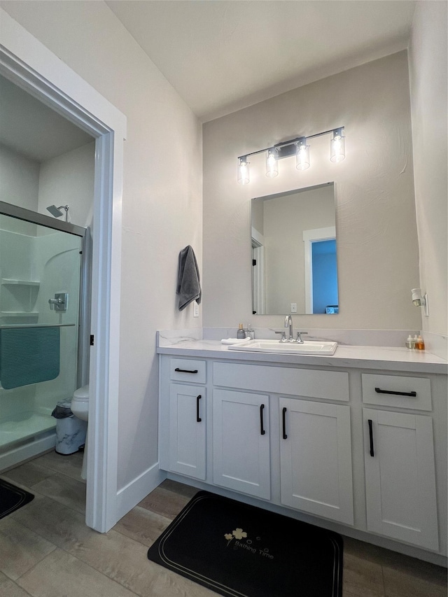 2883 Adam Run Ave, Helena, MT 59601 - bathroom with vanity, a stall shower, wood finished floors, toilet, and baseboards