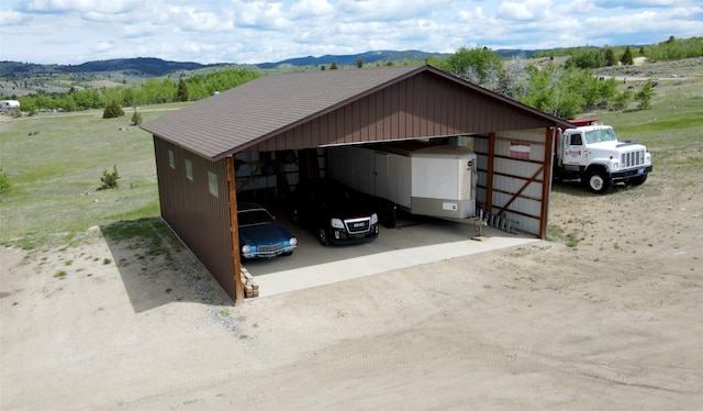 3380 Moulton Reservoir Rd, Butte, MT 59701 - view of outdoor structure featuring a carport, a mountain view, and dirt driveway