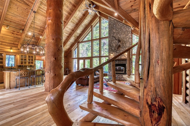 1062 Bear Creek Trl, Victor, MT 59875 - dining space featuring a wooden ceiling with exposed beams, light wood-type flooring, high vaulted ceiling, a stone fireplace, and log walls