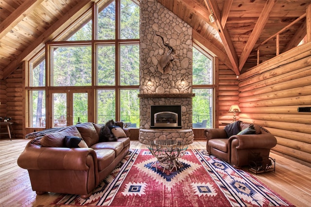 1062 Bear Creek Trl, Victor, MT 59875 - living area featuring high vaulted ceiling, log walls, hardwood / wood-style floors, a wood ceiling with exposed beams, and a fireplace